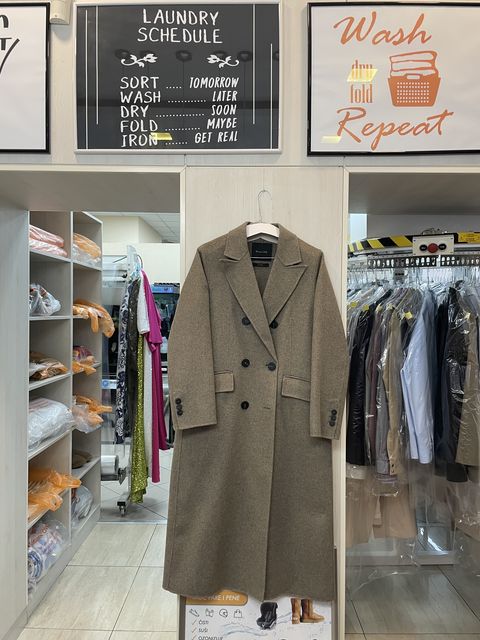 Dugi bež kaput okačen u radnji Elegant